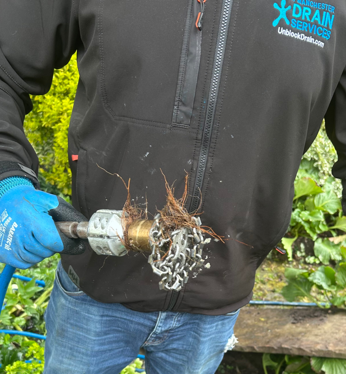 South Manchester Drain Services engineer holding specialist root cutting head with tree roots removed from drain