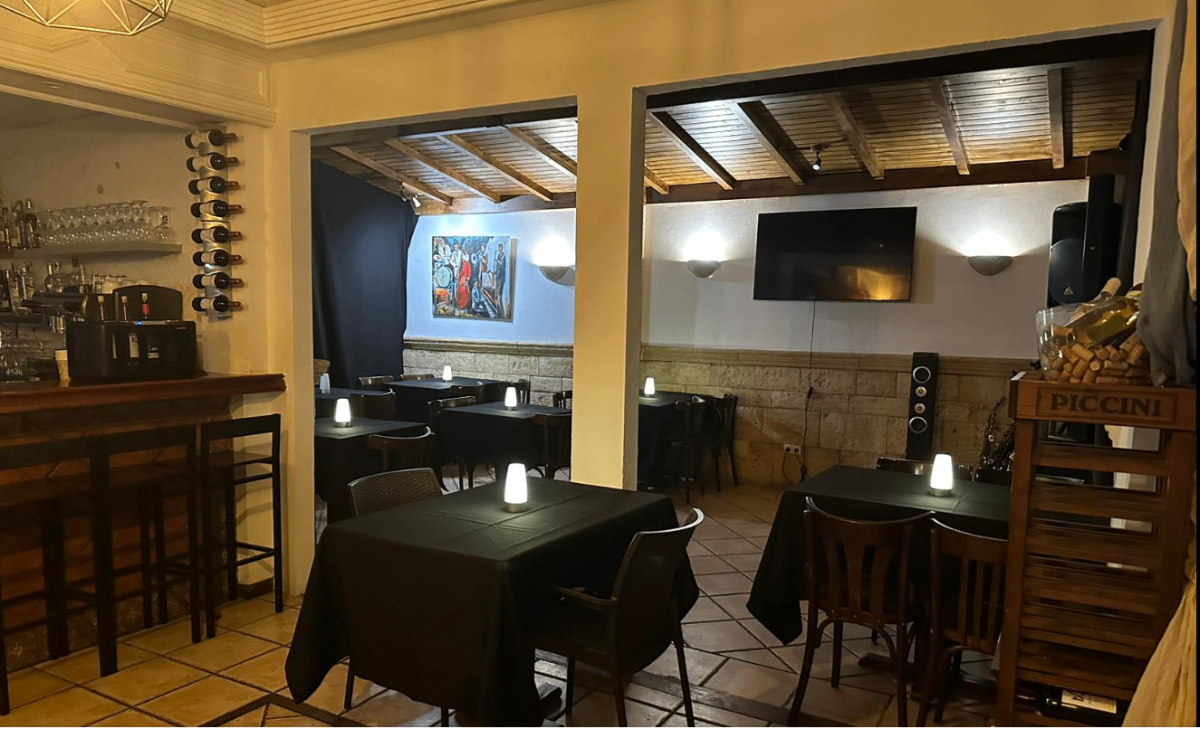 Salón interior nocturno con mesas y velas del restaurante Sofia