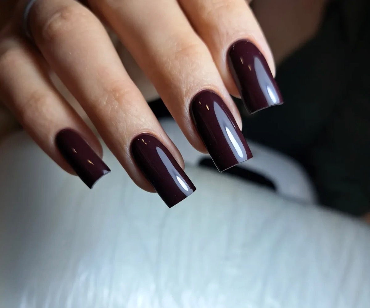 Uñas de gel largas color burdeos con acabado brillante realizadas en Marbella