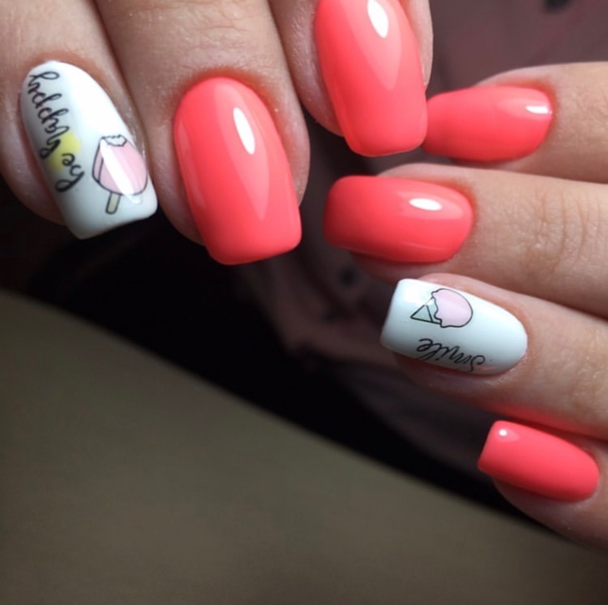 Diseño de uñas color coral con nail art de helado realizado en Marbella