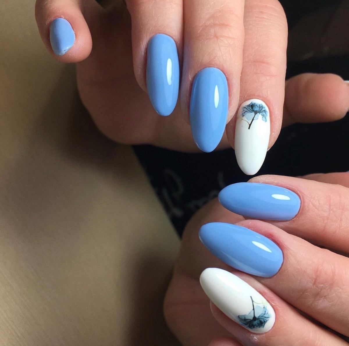 Diseño de uñas de gel color azul con decoración floral minimalista realizado en Marbella