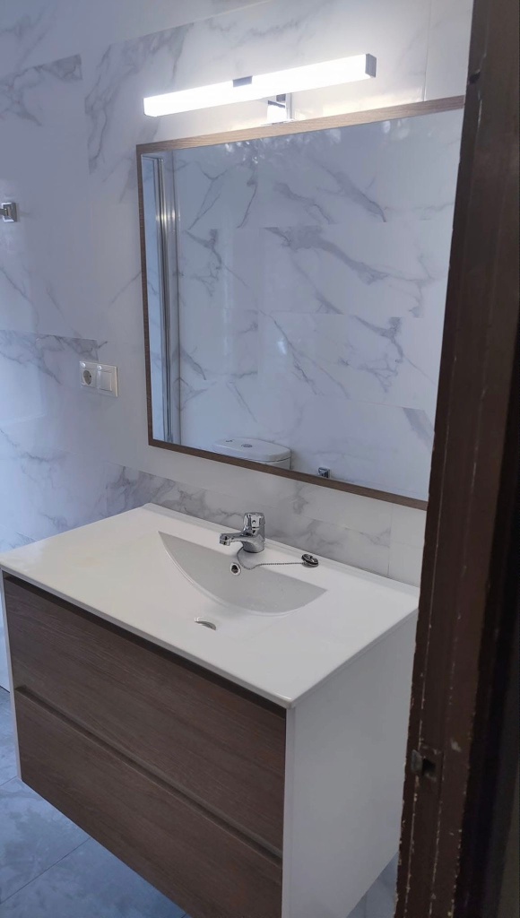Detalle de lavabo moderno con mueble suspendido en madera clara