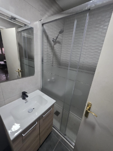 Baño compacto optimizado con plato de ducha y grifería de diseño negra