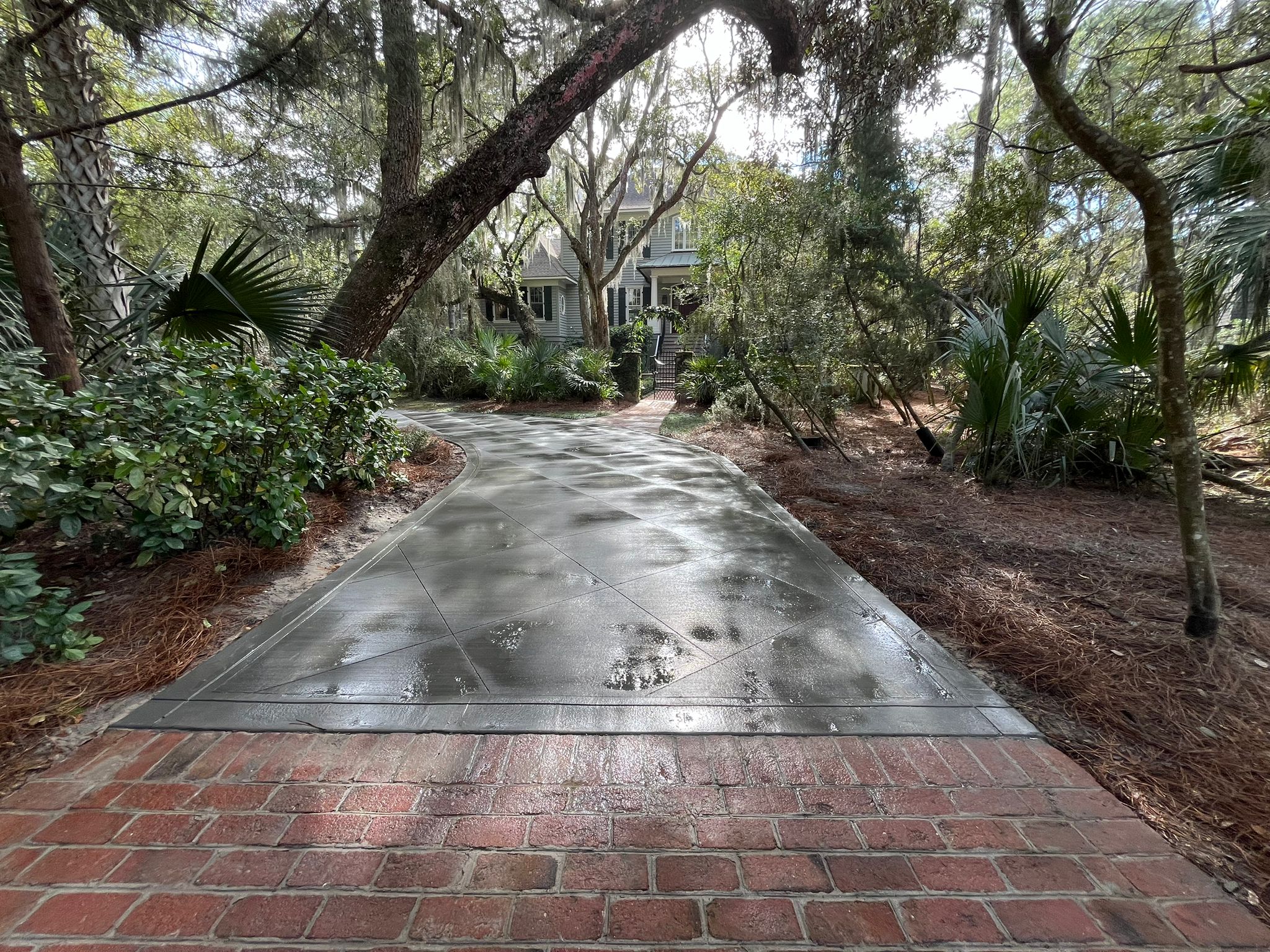 Stamped Cobblestone Concrete Driveway - Charleston SC Stamped concrete driveway with cobblestone pattern in Charleston SC featuring decorative textured finish, earth-tone integral color, reinforced 4000 PSI concrete, proper drainage slope, and UV-resistant sealer for long-lasting curb appeal in humid Lowcountry climate