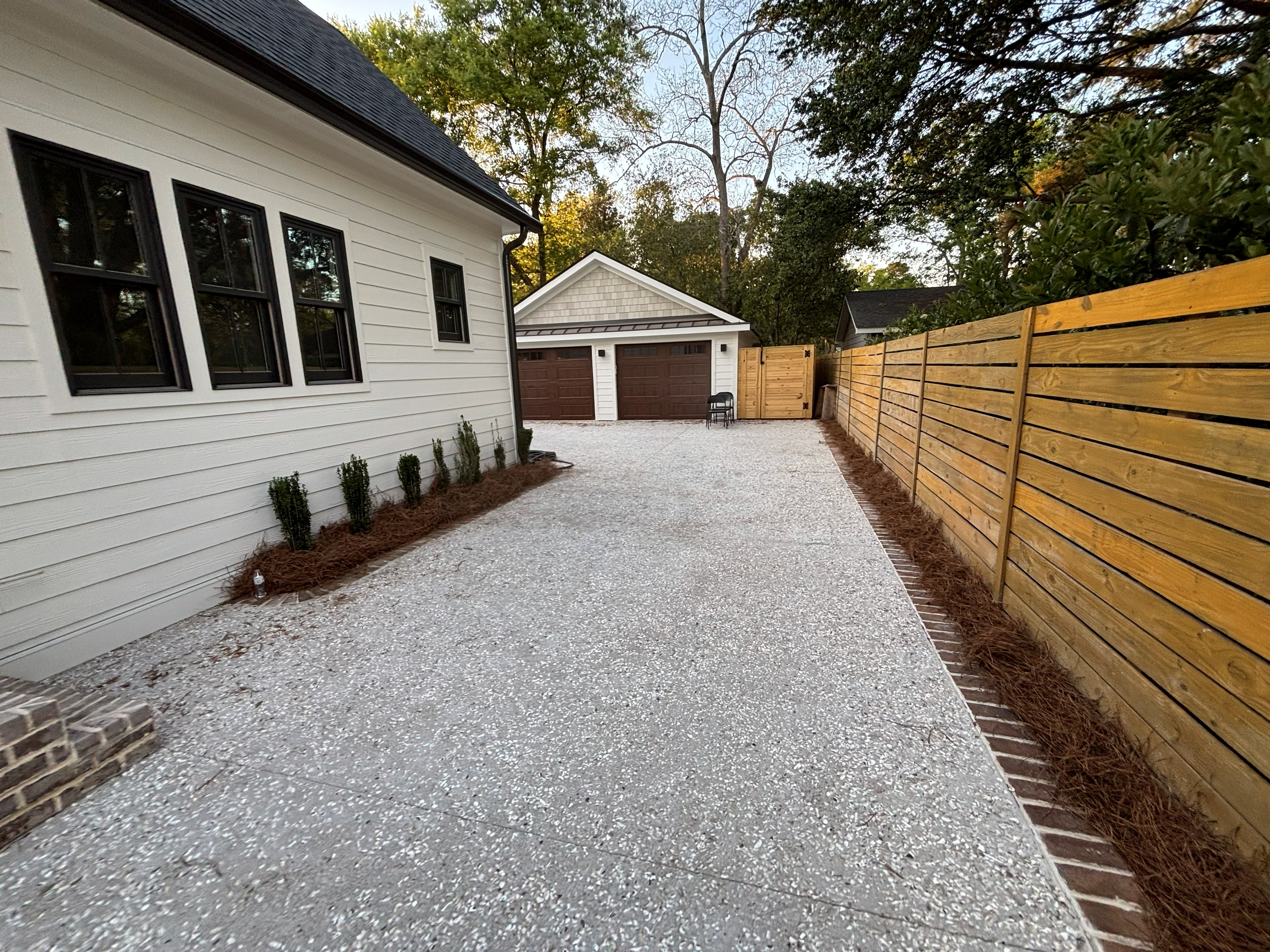 Cobblestone Stamped Entryway West Ashley - Decorative Concrete Curb Appeal Stamped concrete entryway in West Ashley SC with European cobblestone pattern, integral gray color with charcoal antiquing, curved design with soldier course border, 4 inch thickness with wire mesh, slip-resistant texture for safety, UV and weather resistant sealer, proper drainage slope, elegant curb appeal enhancement for Charleston residential properties