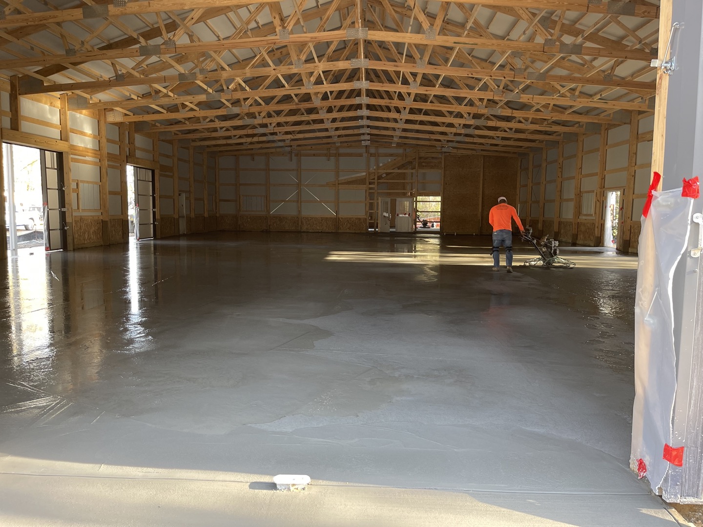 Concrete slab construction process showing site excavation and grading, 4-6 inch compacted gravel base preparation, 6 mil polyethylene vapor barrier installation, #4 steel rebar grid reinforcement with 12 inch spacing, wooden formwork construction, 6-8 inch thick 4000 PSI concrete pouring and spreading, vibration consolidation, smooth trowel finishing, control joint cutting, proper curing methods, garage floor slab, commercial utility pad, shed foundation, and professional workmanship in Charleston SC Lowcountry