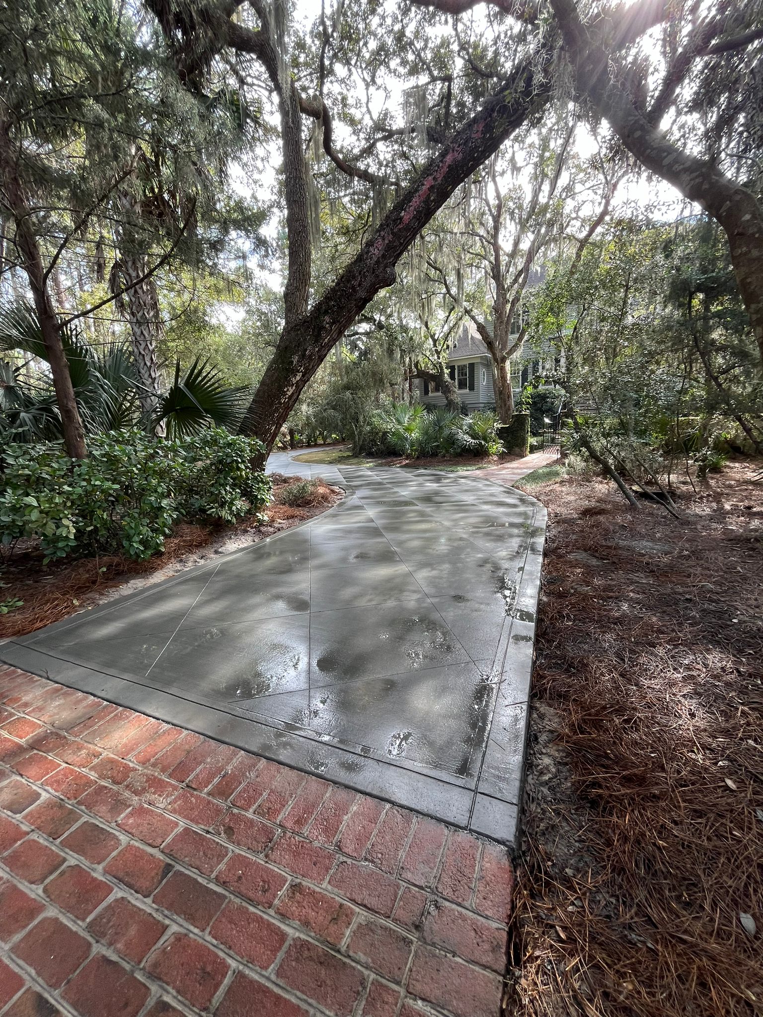 Decorative Concrete Before After - Charleston Concrete Transformation Services Decorative concrete transformation showing before and after comparison in Charleston SC, plain gray concrete converted to beautiful stamped pattern with slate texture, warm brown acid stain color, professional surface preparation with diamond grinding, polymer-modified overlay application, high-performance acrylic sealer with wet look finish, expert color blending and antiquing techniques for depth and character