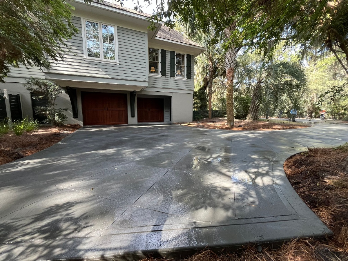 Driveway Replacement Charleston SC - Complete Concrete Driveway Installation Professional concrete driveway replacement project in Charleston SC showing complete removal of old damaged driveway and installation of new reinforced concrete with proper grading, compacted base, steel rebar reinforcement, and broom finish texture for residential property in Lowcountry area