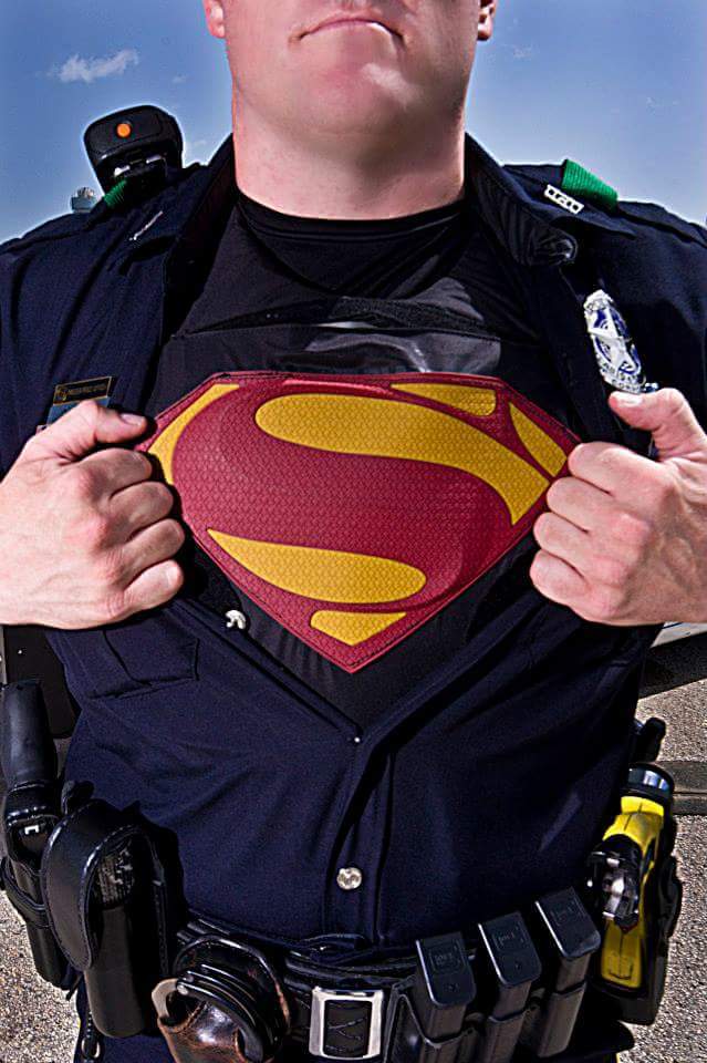 Police officer showing Superman logo to children