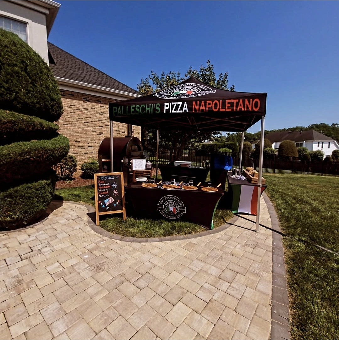 Palleschi's Pizza Napoletano tent setup at backyard event with wood-fired oven