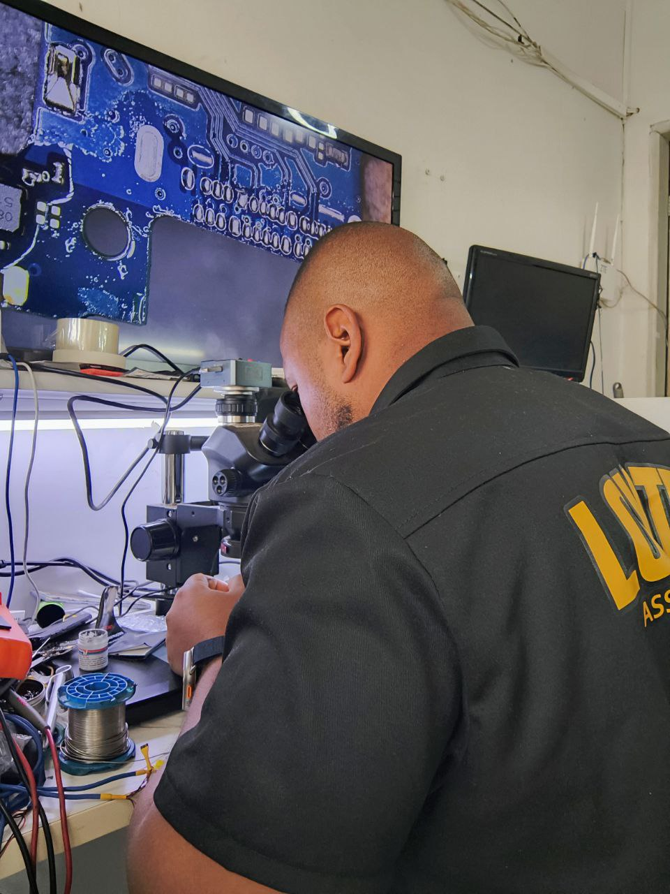 Técnico especializado da Loy Tech realizando reparo em smartphone